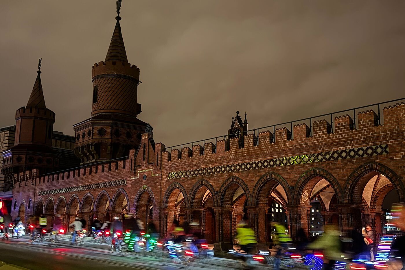 Leuchtende Radfahrende bei Nacht auf der Oberbaumbrücke