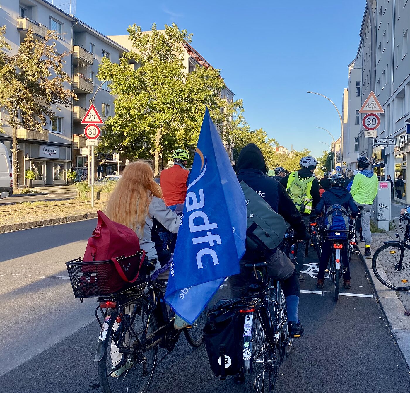 Eine Gruppe Radfahrende steht auf einem Radweg auf der Grunewaldstraße in Berlin Schöneberg Richtung Kleistpark