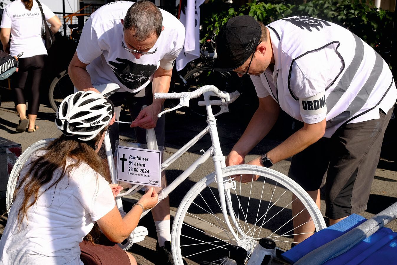 Ein Gedenkschild wird an dem Geisterrad für den 81-jährigen Radfahrer festgemacht.