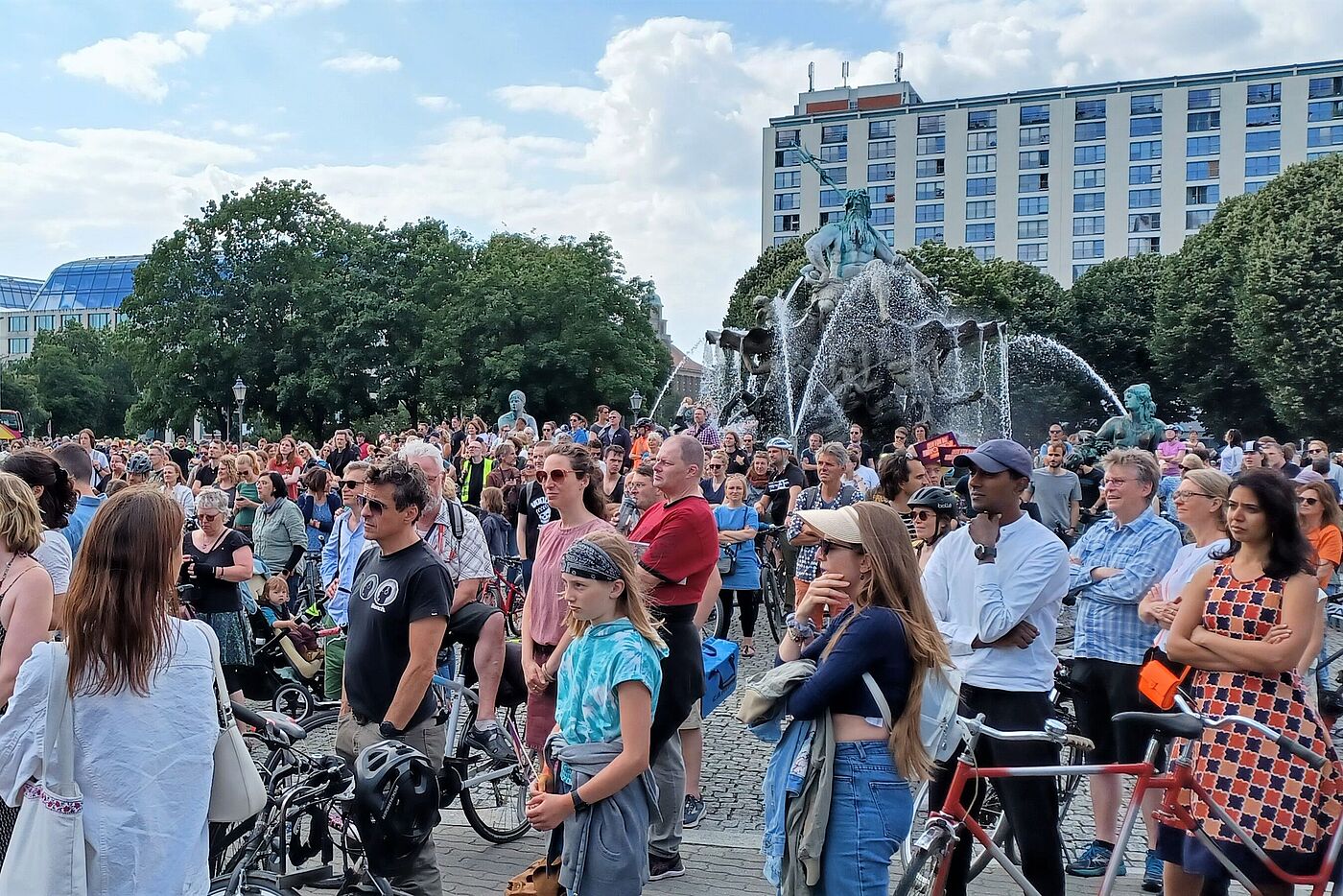 Menschen stehen um den Neptunbrunnen und hören der Abschlusskundgebung zu