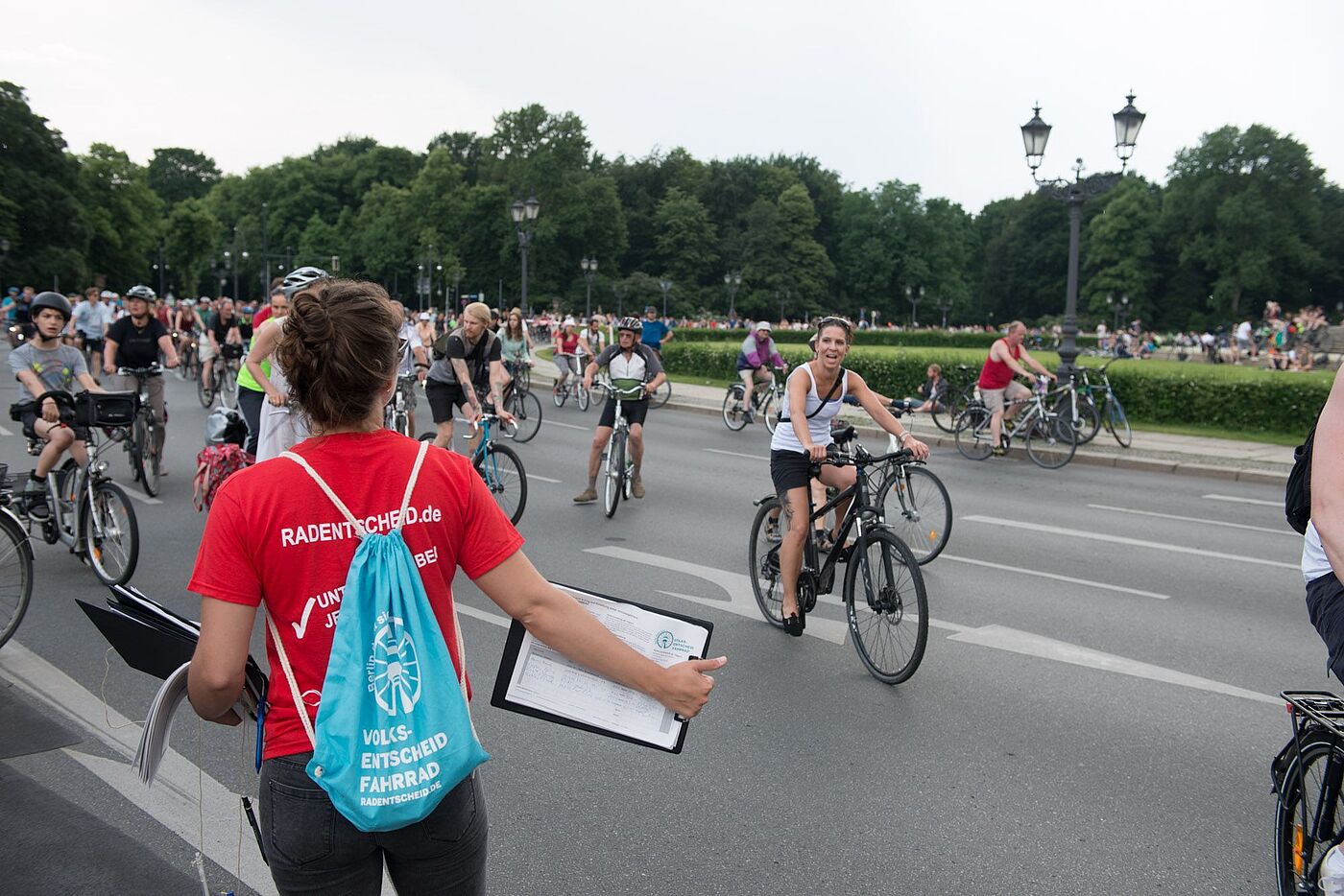 Frau mit rotem T-Shirt und Unterschriftenliste für den Volksentscheid bei der Siegessäule