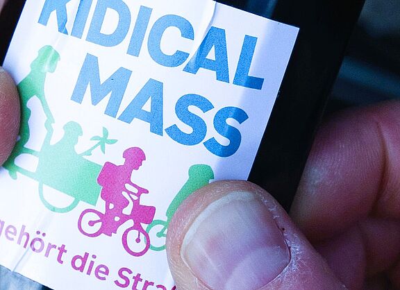 Ein Kidical Mass Aufkleber wird auf ein Schutzblech geklebt