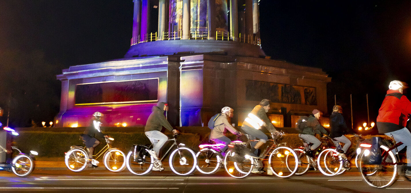 ADFC Lichterfahrt 2024 Großer Stern Radfahrende auf erleuchteten Rädern fahren vorbei an der Siegessäule