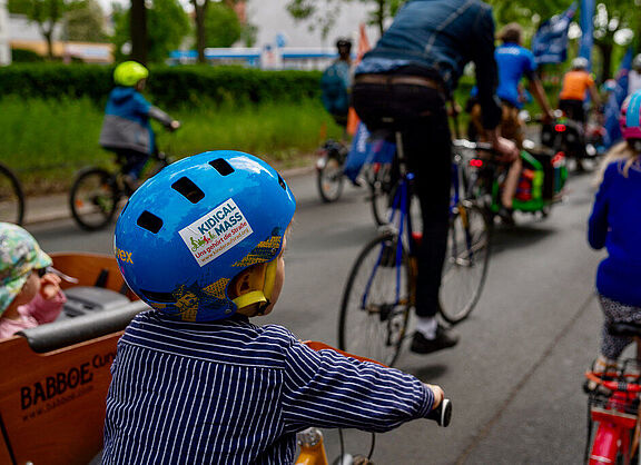 Kind mit Helm nimmt an Kidical Mass teil