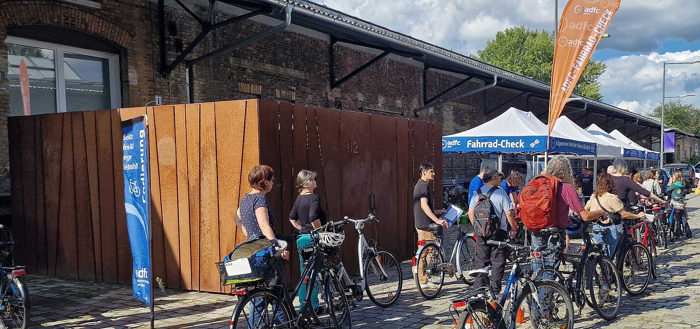 Menschen stehen mit ihren Fahrrädern in der Schlange für den ADFC-Fahrrad-Check