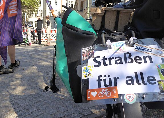 Kidical Mass Schöneberg: Straßen für alle! Auf einem Schild, das am Gespäckträger eines Fahrrads hängt, steht "Straßen für alle".