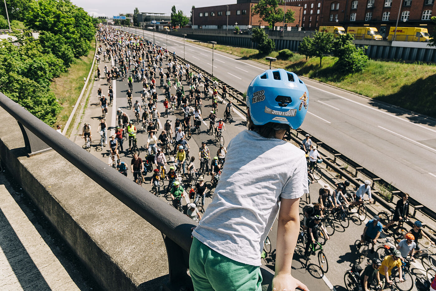 Kind schaut auf die ADFC Fahrradsternfahrt auf der Autobahn hinunter