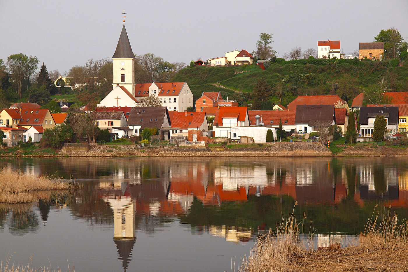 Blick über einen See auf ein Dorf