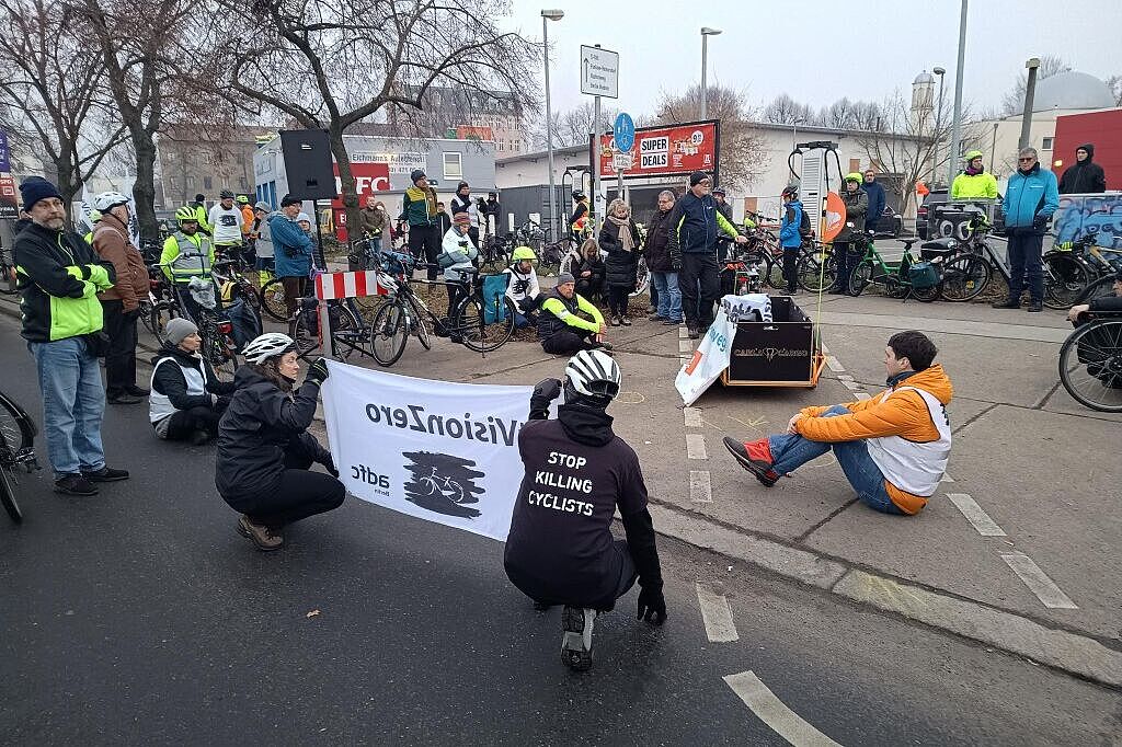 Menschen bei einer Mahnwache für einen getöteten Radfahrer auf der Straße