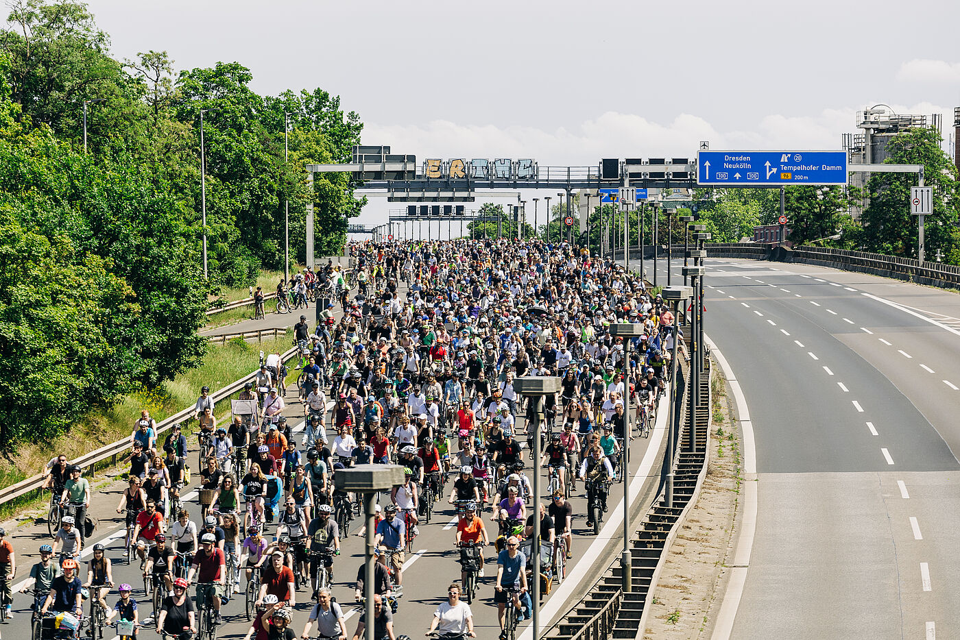 Radfahrende fahren auf der einen Seite der Autobahn während die andere komplett leer ist