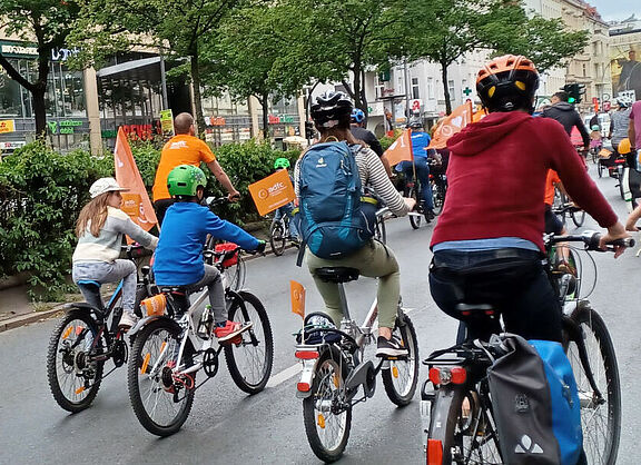 Glückliche Kinder radeln bei der KidicalMass über große Straßen