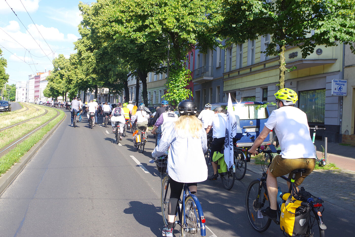 Menschen mit weißen T-Shirts fahren bei einer Vision-Zero Demonstration zum Unfallort