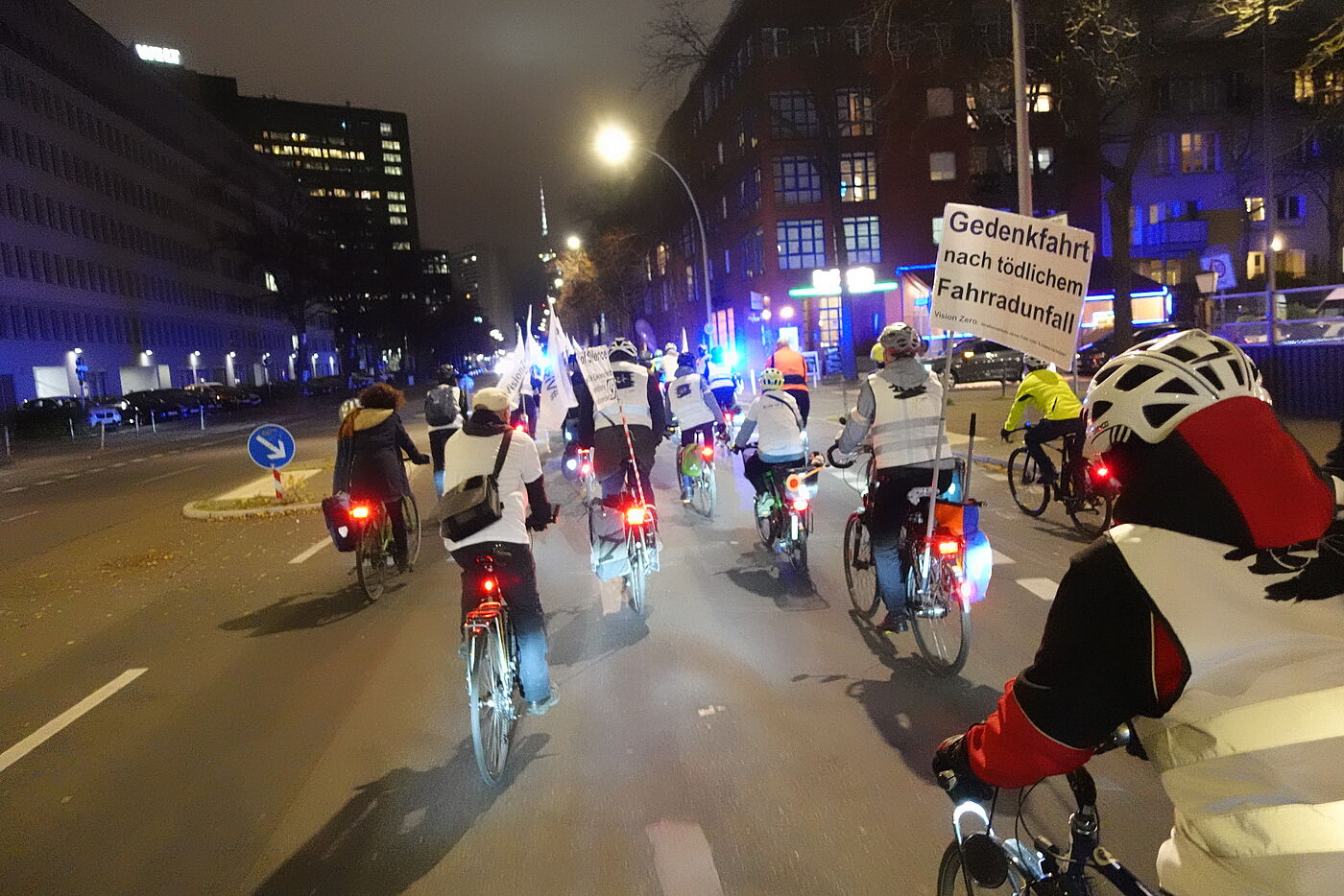 Menschen bei einer Vision Zero Fahrraddemonstration mit weißen Schildern und Warnwesten