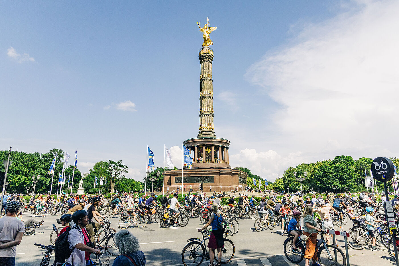 Menschen fahren mit dem Fahrrad um die Siegessäule in Berlin