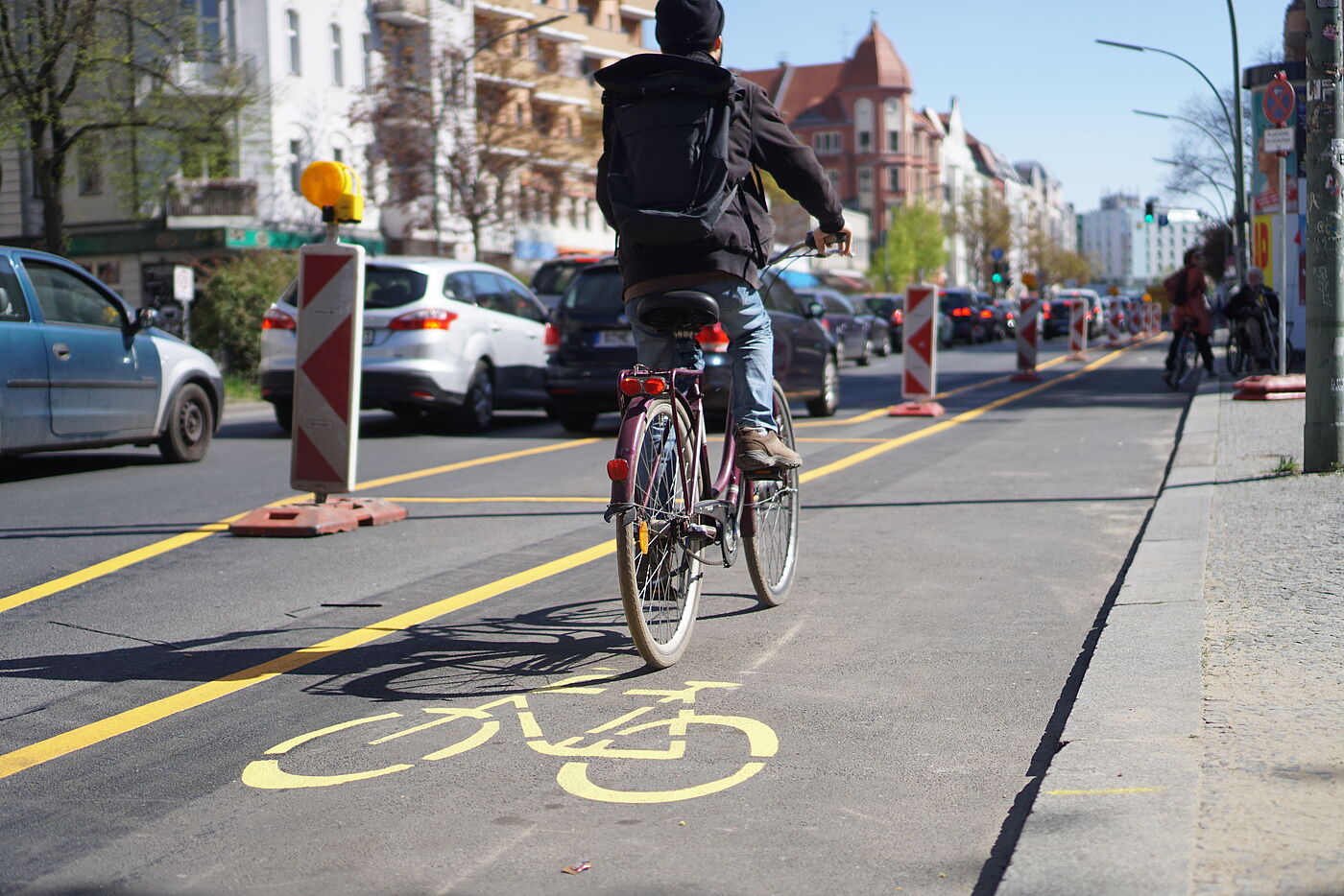 Pop-Up-Bikelane mit Pollern und gelber Farbe, Radfahrer