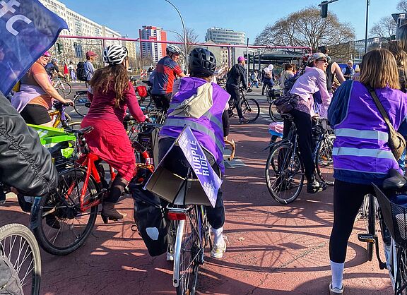 Beim Purple Ride am 08.03.2025 sind mehrere Teilnehmerinnen zu sehen, und auch eine Flagge des ADFC Berlin