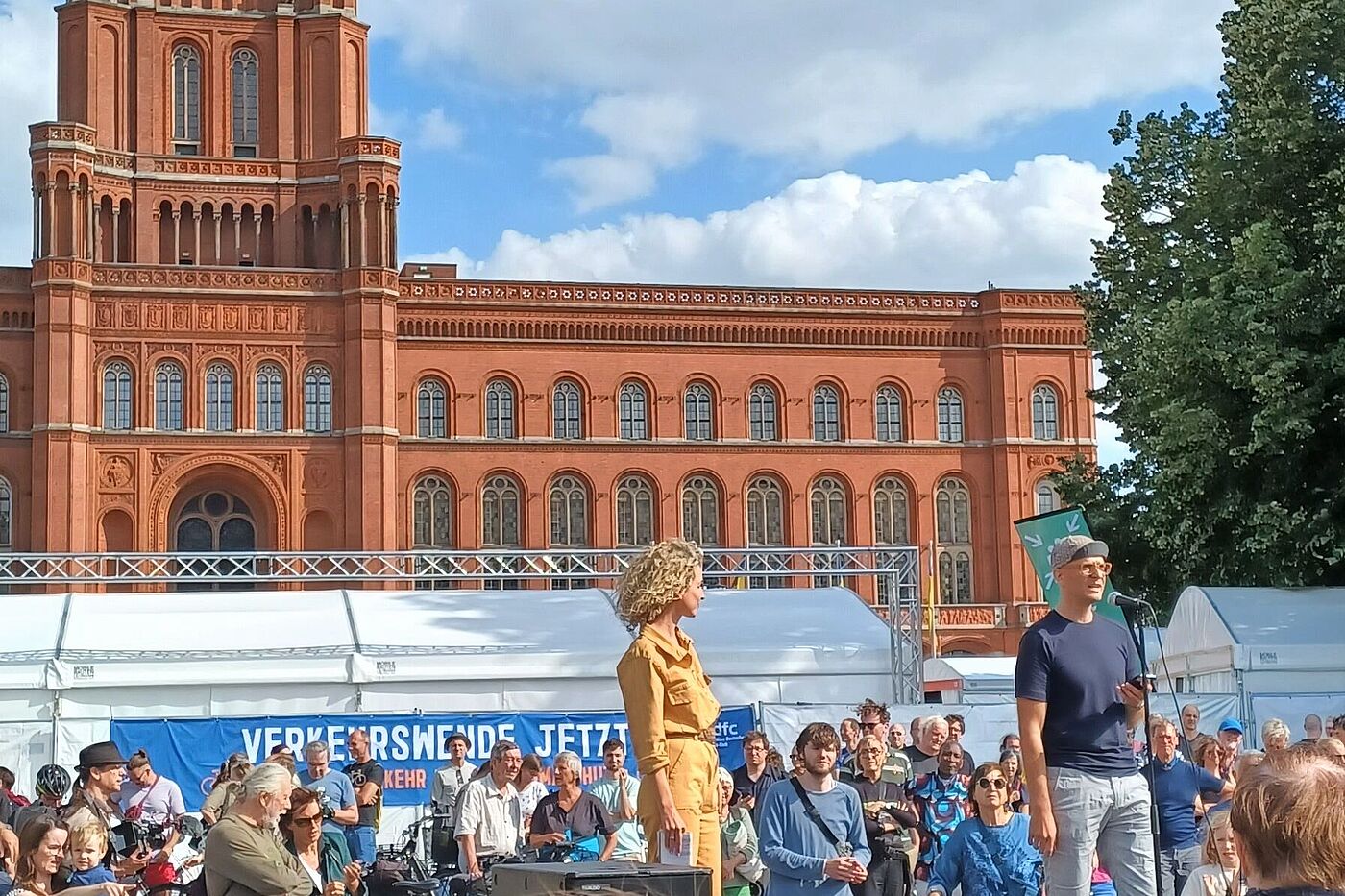 Evan Vosberg (Vorstand ADFC Berlin) spricht auf einer Bühne vor dem Roten Rathaus