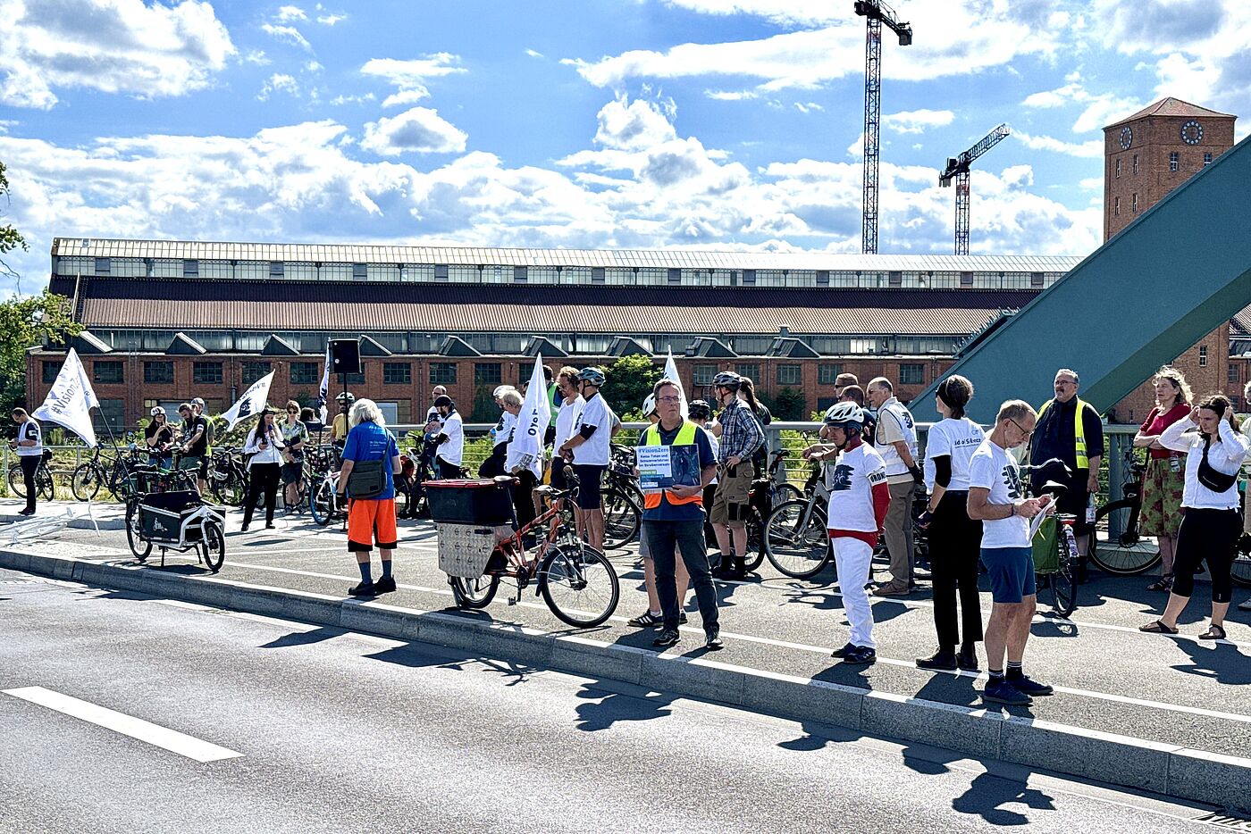 Menschen mit weißen T-Shirts gedenken bei einer Vision Zero einem getöten Radfahrer