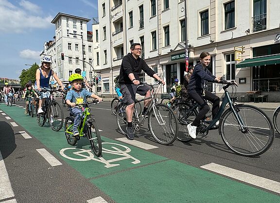 Erwachsene und Kinder fahren auf dem Fahrrad durch die Stadt