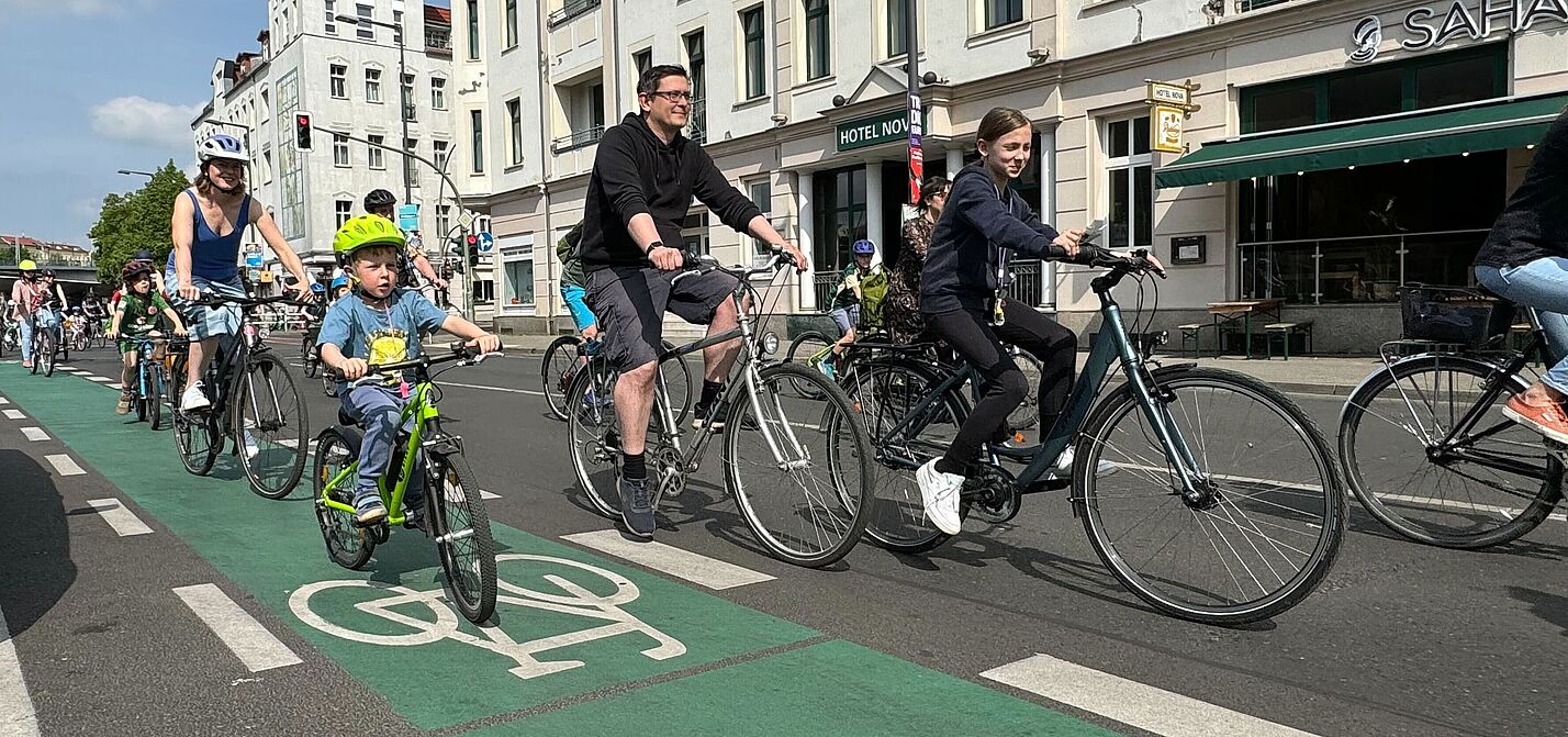 Erwachsene und Kinder fahren auf dem Fahrrad durch die Stadt