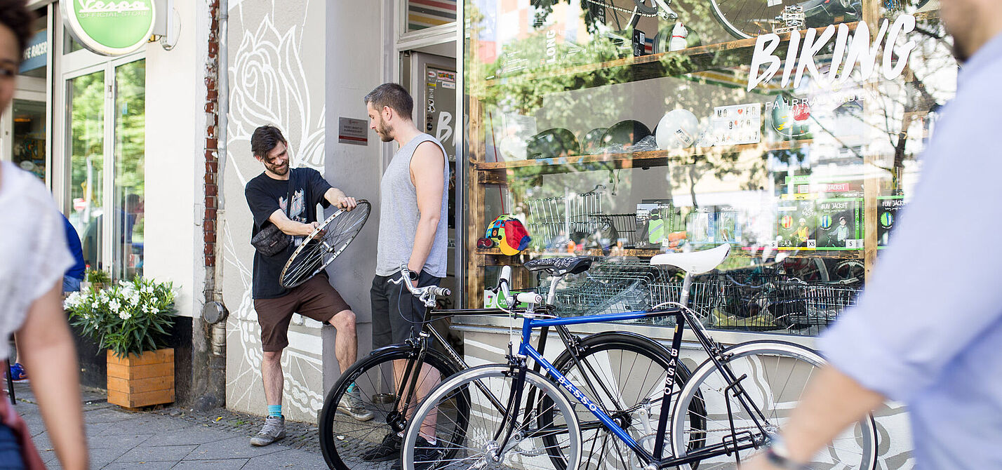 zwei Männer vor einem Fahrradladen