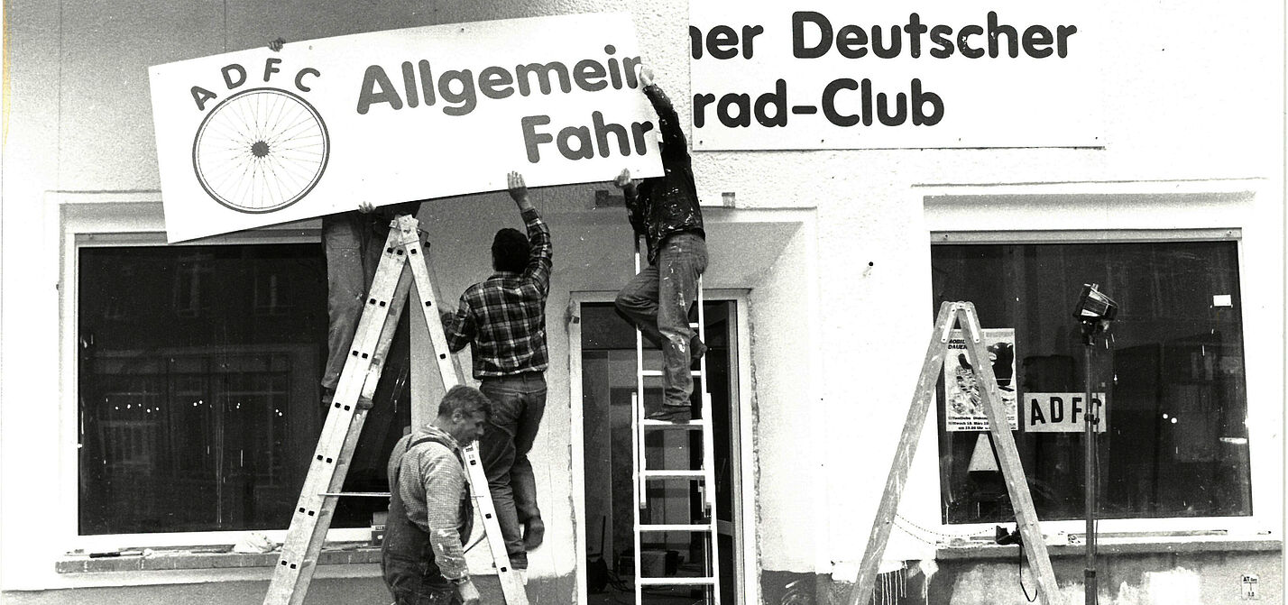 Männer hängen ein Allgemeiner Deutscher Fahrrad Club-Schild auf