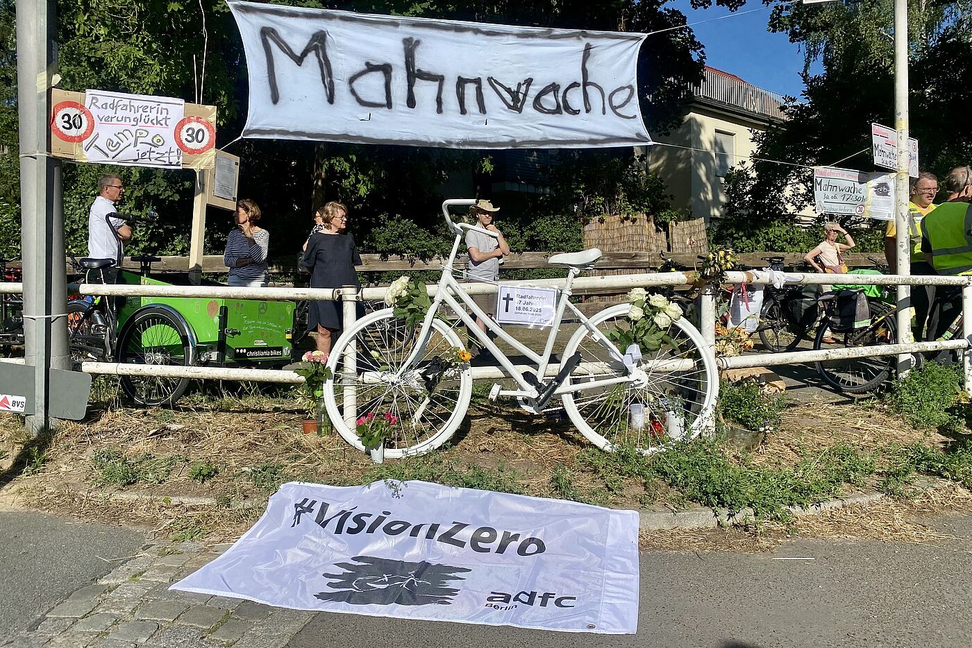 Eine weiße VisionZero Fahne des ADFC Berlin kennzeichnet die Stelle, an der eine Radfahrerin auf der Berliner Clayallee angefahren wurde.