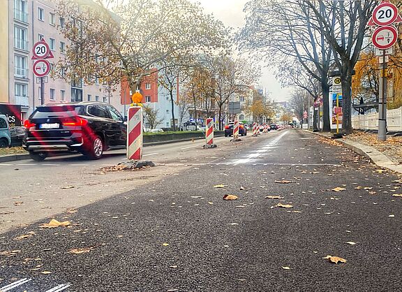 Zwischen Martin-Luther-Straße und Bayerischem Platz ist eine frisch asphaltierte Fahrbahn am rechten Rand durch einen weißen Streifen und Baken von der Spur für Autos weiter in der Mitte abgegrenzt. 