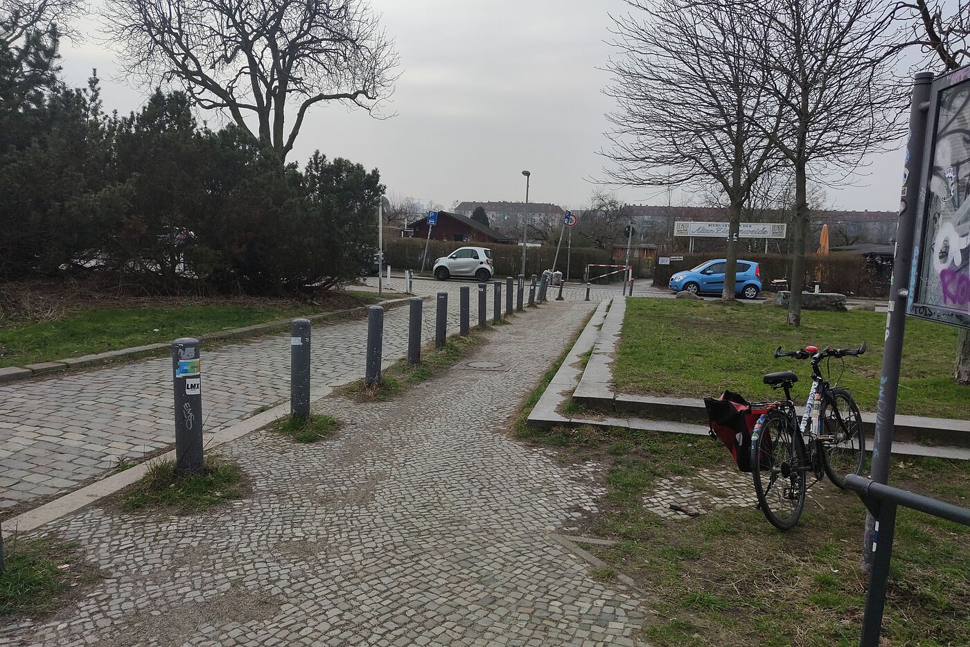 gepflasterter schmaler Gehweg neben Kopfsteinpflasterstraße