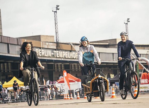 Menschen auf Fahrrädern vor dem Flughafen Tempelhof in Berlin