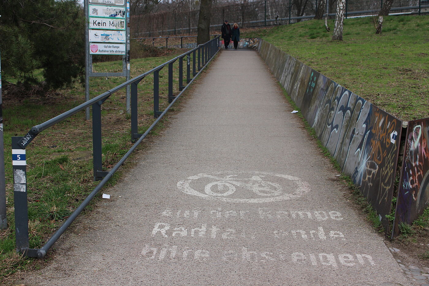 schmale Rampe mit verblasster Schrift: Radfahrer bitte absteigen