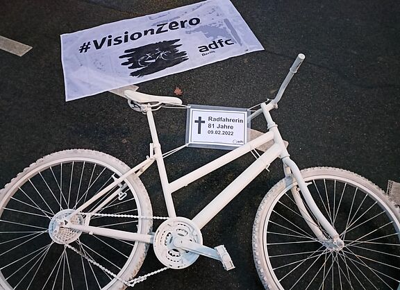 Während der Mahnwache markieren das Geisterrad und das #VisionZero-Banner die Unfallstelle