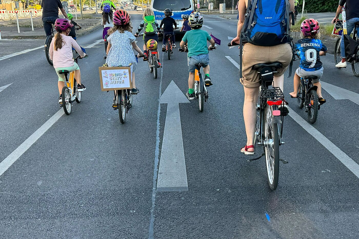 Kinder fahren bei einer Fahrraddemo hinter einem Polizeiauto