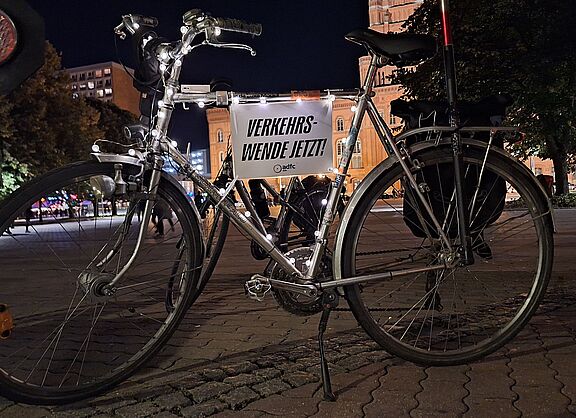 ein silbernes Fahrrad mit Lichterkette und Schild auf dem steht: Verkehrswende jetzt