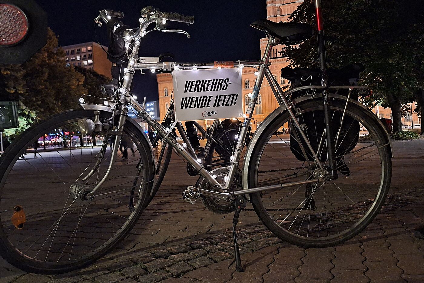 ein silbernes Fahrrad mit Lichterkette und Schild auf dem steht: Verkehrswende jetzt