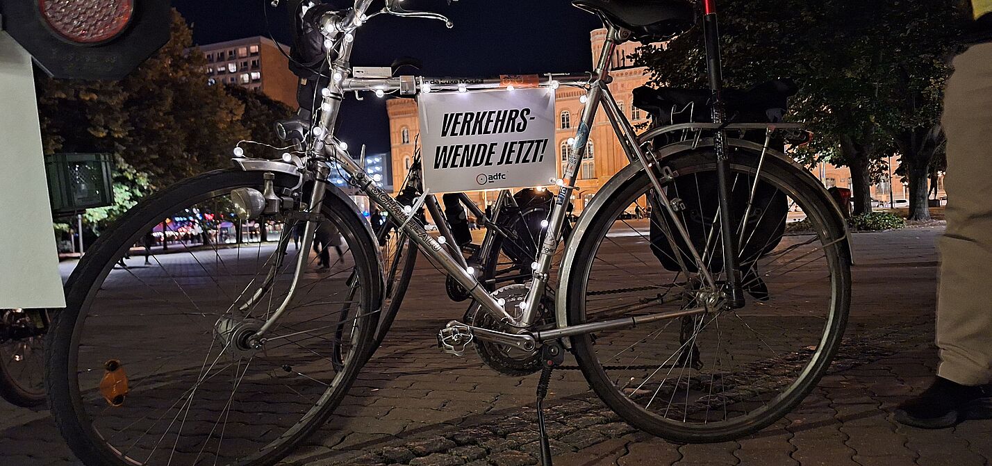 ein silbernes Fahrrad mit Lichterkette und Schild auf dem steht: Verkehrswende jetzt