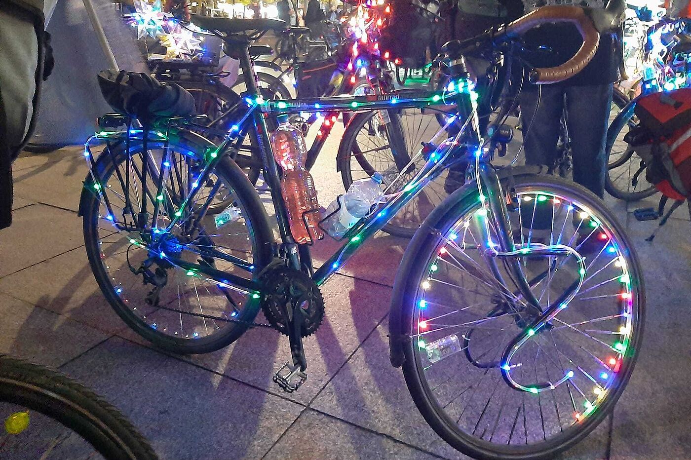 Ein Fahrrad geschmückt mit bunten Lichterketten