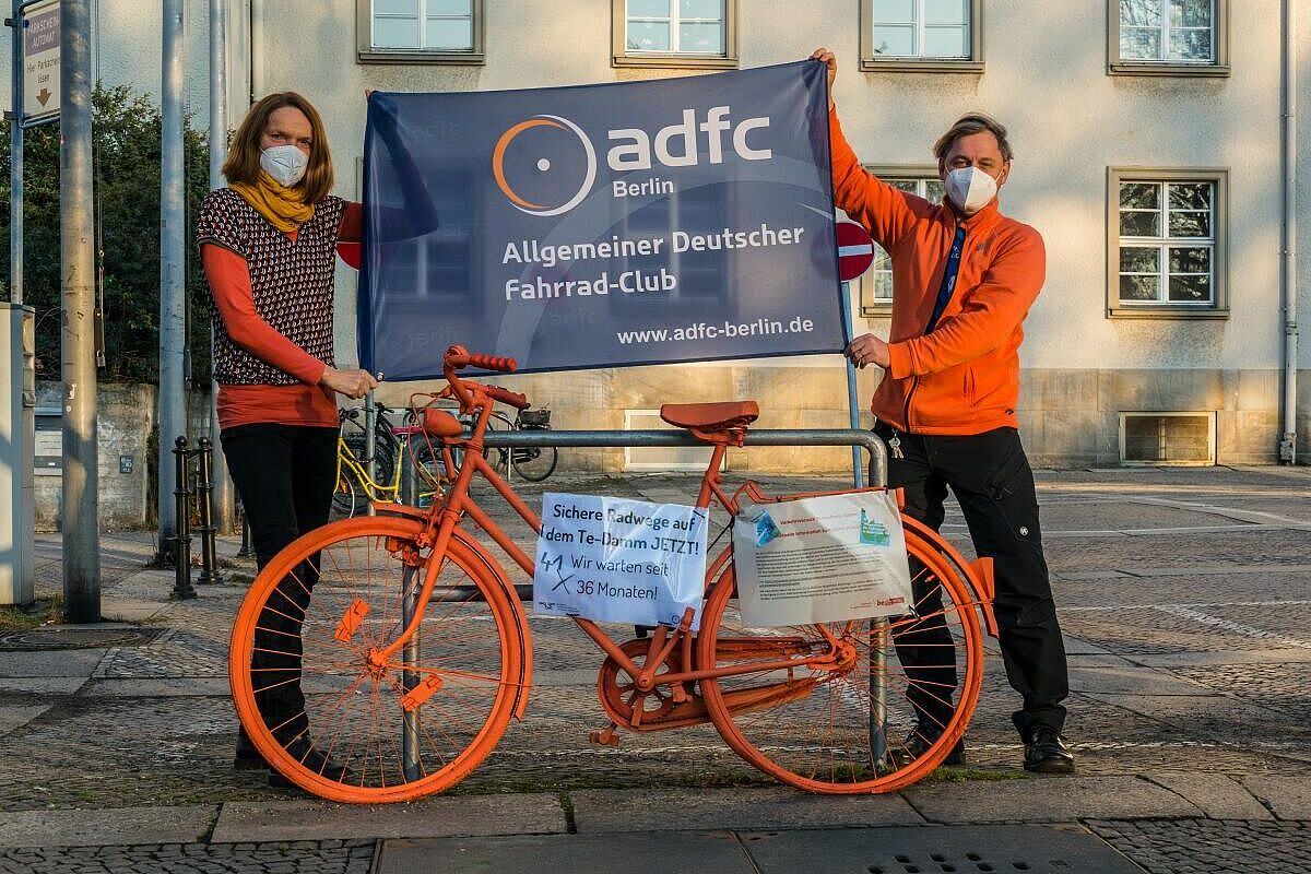 Zwei Mitglieder der Stadtteilgruppe Tempelhof halten Plakate hoch