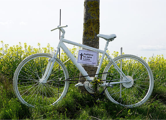 Ein weißes Geisterrad vor einem gelb blühenden Feld