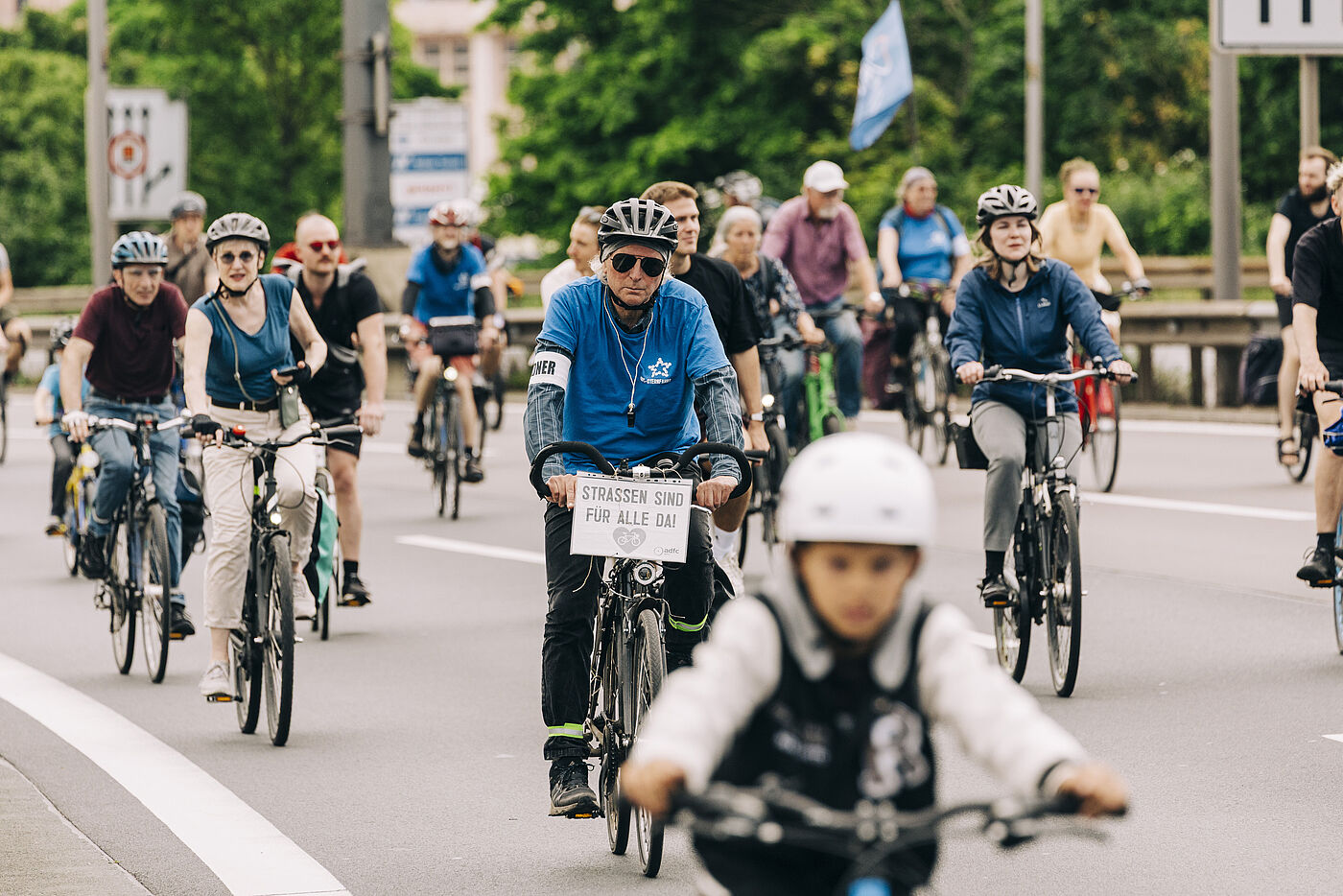 Radfahrende bei der Sternfahrt mit Mottoschild: Straßen sind für alle da