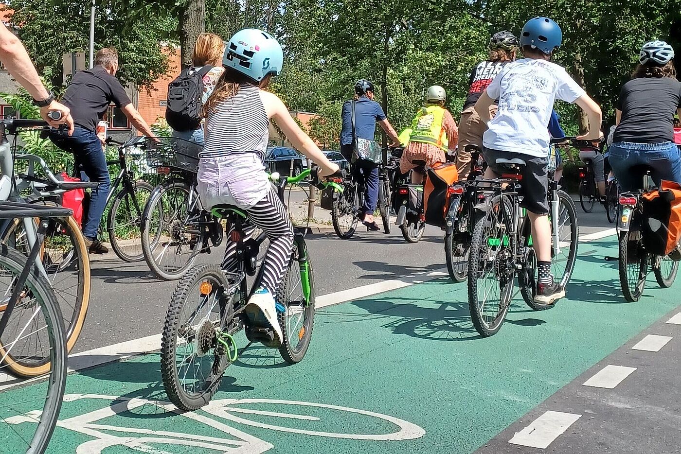 Kinder fahren auf einem grünen Radfahrstreifen