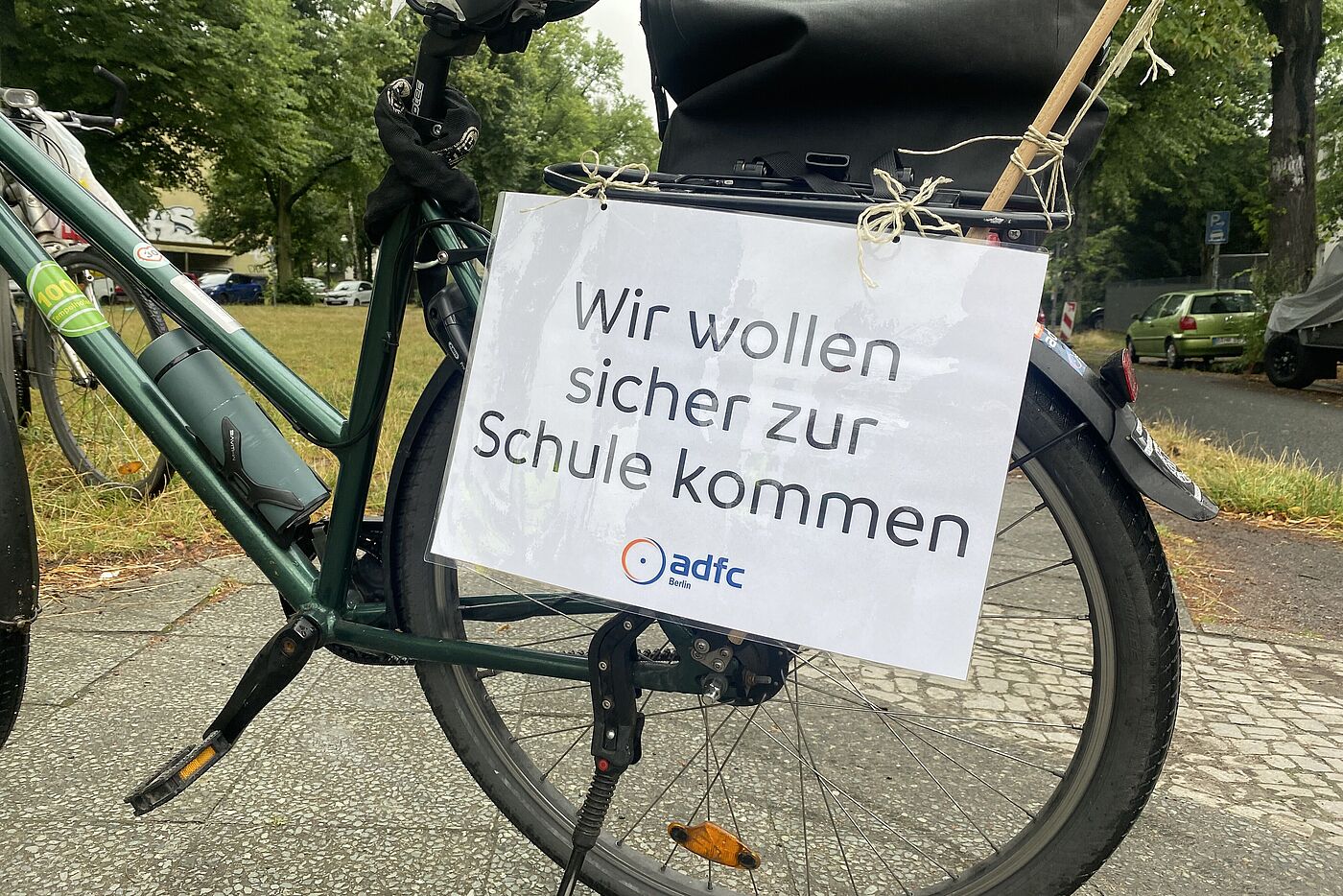 Laminiertes Schild des ADFC Berlin mit der Aufschrift "Wir wollen sicher zur Schule kommen!"