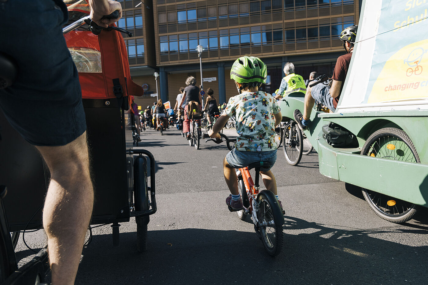 Lastenrad und Kind auf Fahrrad von hinten