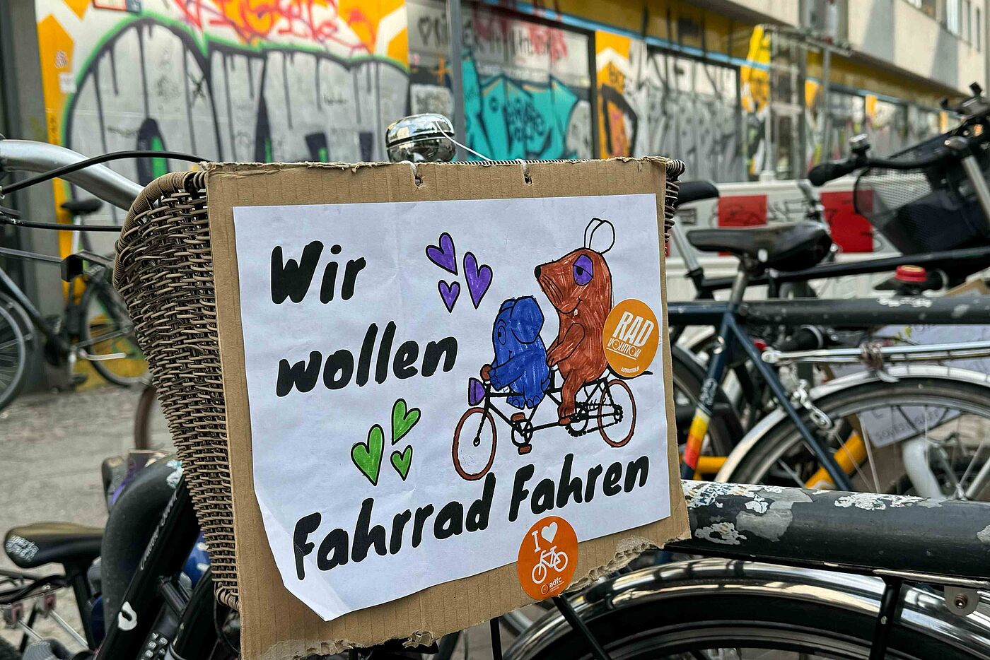 Selbstgemaltes Schild an Fahrrad mit der Maus und Elefanten auf dem steht: Wir wollen Fahrrad fahren