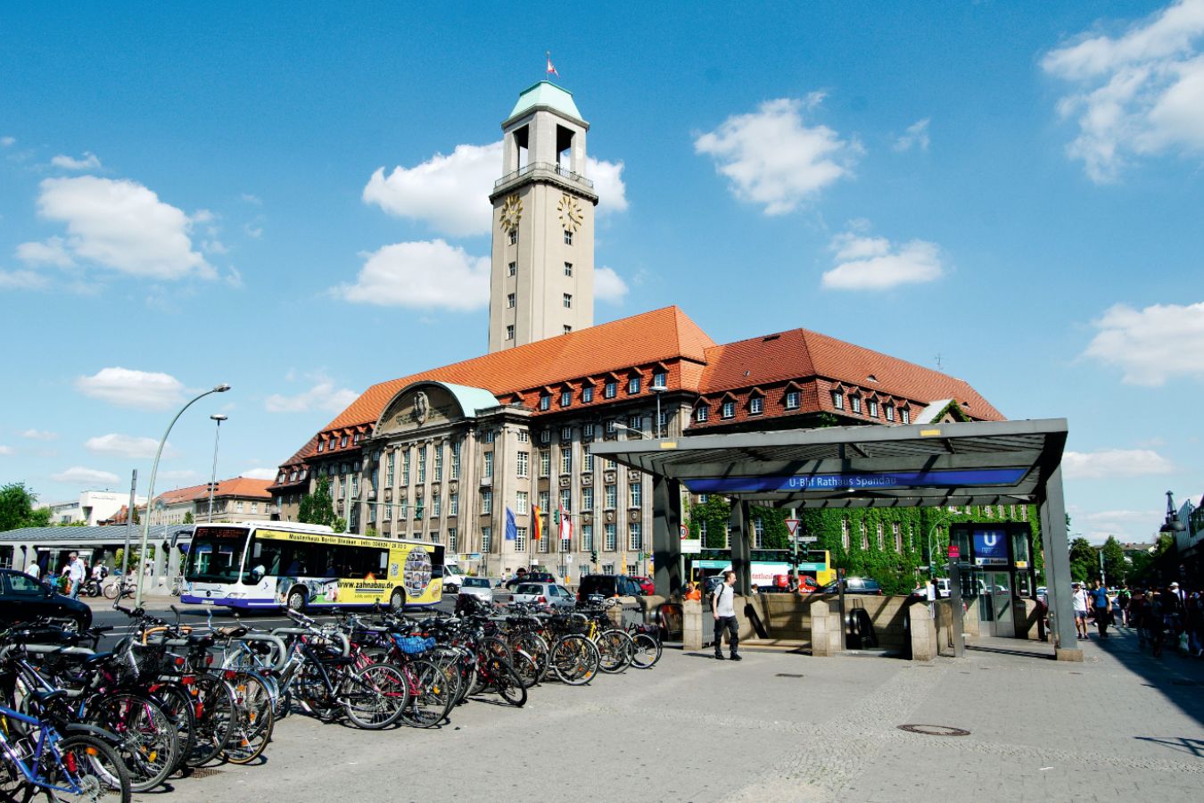 Das Rathaus Spandau, davor der Eingang zur U-Bahn, links davon die bis zum letzten Platz besetzten Fahrradbügel.