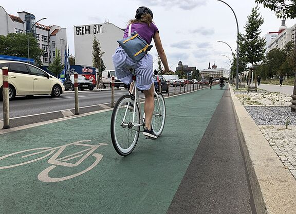 Frau auf geschütztem Radfahrstreifen