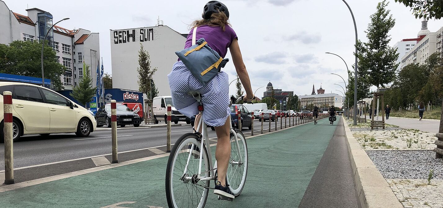 Frau auf geschütztem Radfahrstreifen